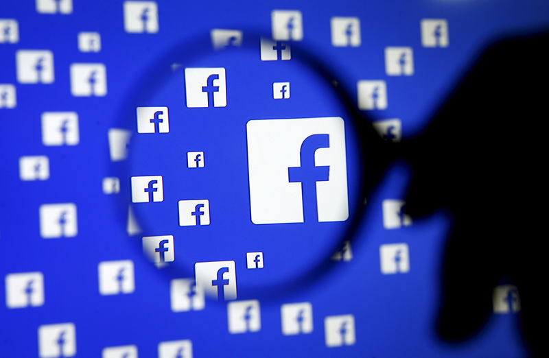 © Reuters. FILE PHOTO: A man poses with a magnifier in front of a Facebook logo on display in this illustration taken in Sarajevo