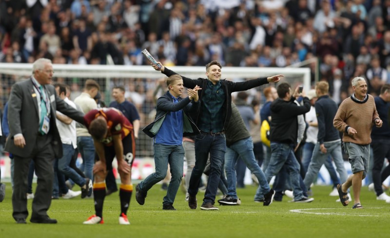 © Reuters. Millwall fans invade the pitch as they celebrate after getting promoted to the Sky Bet Championship