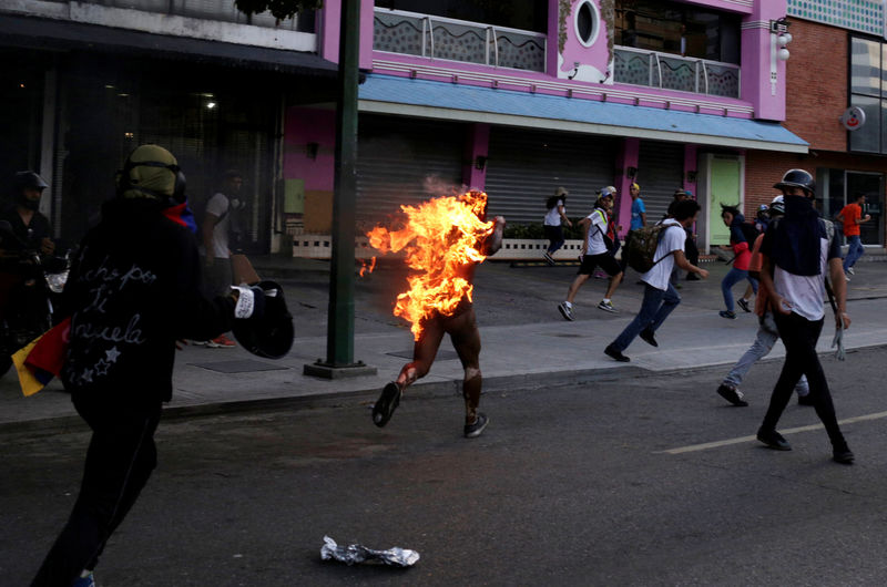 © Reuters. A Picture and its Story: Man set on fire during Venezuela protests