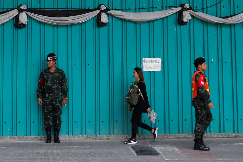 © Reuters. A woman walks past Thai military personnel at the Phramongkutklao Hospital in Bangkok
