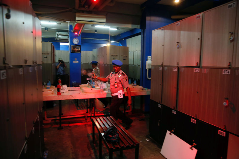 © Reuters. A police officer sprays air freshener inside the club where police detained 141 men for what they described as a gay prostitution ring, in Jakarta