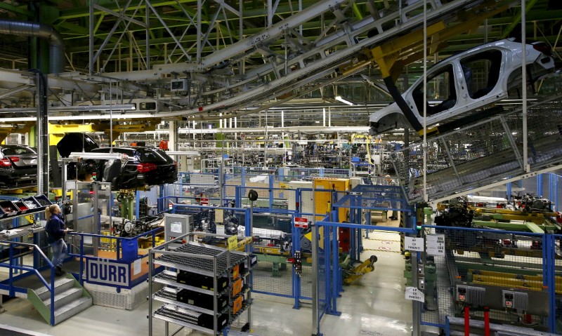 © Reuters. An employee of German car manufacturer Mercedes Benz observes the connection between the bodywork and the chassis of an A class (A-Klasse) model at their production line at the factory in Rastatt