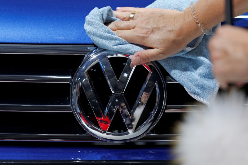 © Reuters. A worker shines the grill of a Volkswagen car displayed on media day at the Paris auto show, in Paris