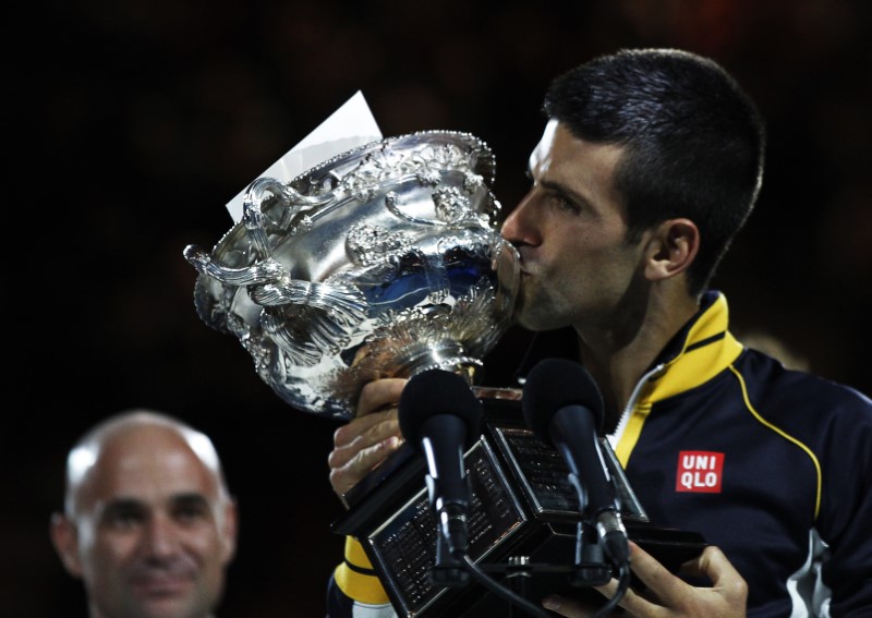 © Reuters. FILE PHOTO: Former tennis player Andre Agassi of the U.S. looks on as Novak Djokovic of Serbia kisses the Norman Brookes Challenge Cup after he defeated Andy Murray of Britain in their men's singles final match at the Australian Open tennis tournament in Melbourne