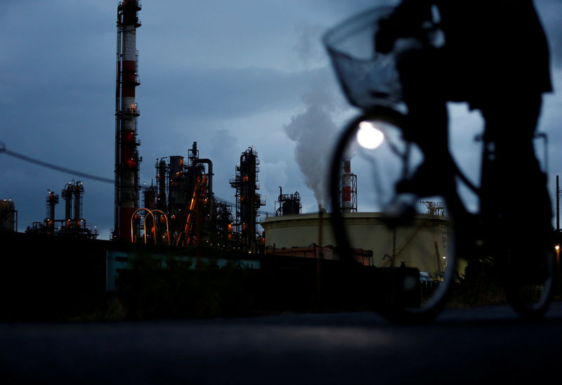 © Reuters. FILE PHOTO: A bicycle rider rides past a factory at Keihin industrial zone in Kawasaki