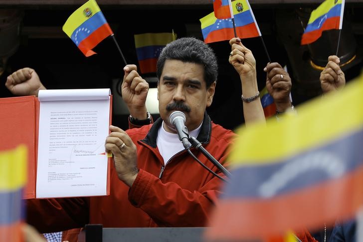 © Reuters. Venezuela's President Nicolas Maduro shows a document with the details of a "constituent assembly" to reform the constitution during a rally at Miraflores Palace in Caracas, Venezuela
