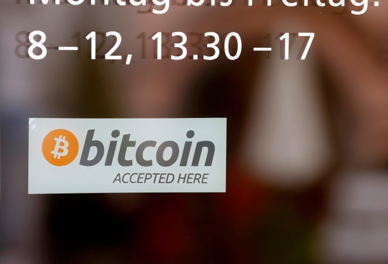 © Reuters. A sticker reading "Bitcoin accepted here" is displayed at the entrance of the Stadthaus town hall in Zug