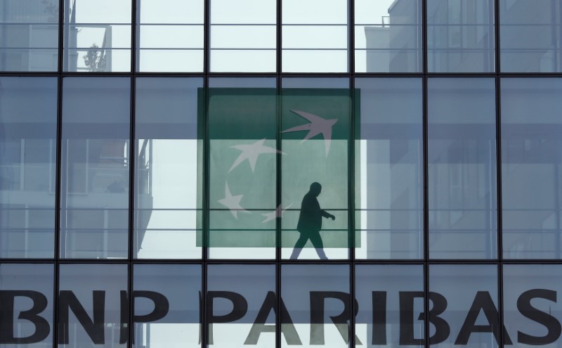 © Reuters. FILE PHOTO: A man is seen in silhouette as he walks behind the logo of BNP Paribas in a building in Issy-les-Moulineaux, near Paris