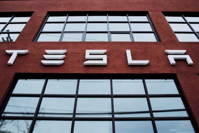© Reuters. FILE PHOTO: A Tesla logo hangs on a building outside of a Tesla dealership in New York