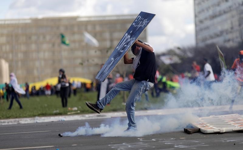 © Reuters. Un manifestante se enfrenta a policía antidisturbios durante una manifestación contra el presidente brasileño Michel Temer en Brasilia.