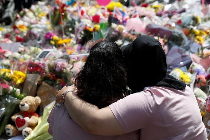 © Reuters. Pessoas observam homenagem às vítimas de ataque na Arena de Manchester, no Reino Unido