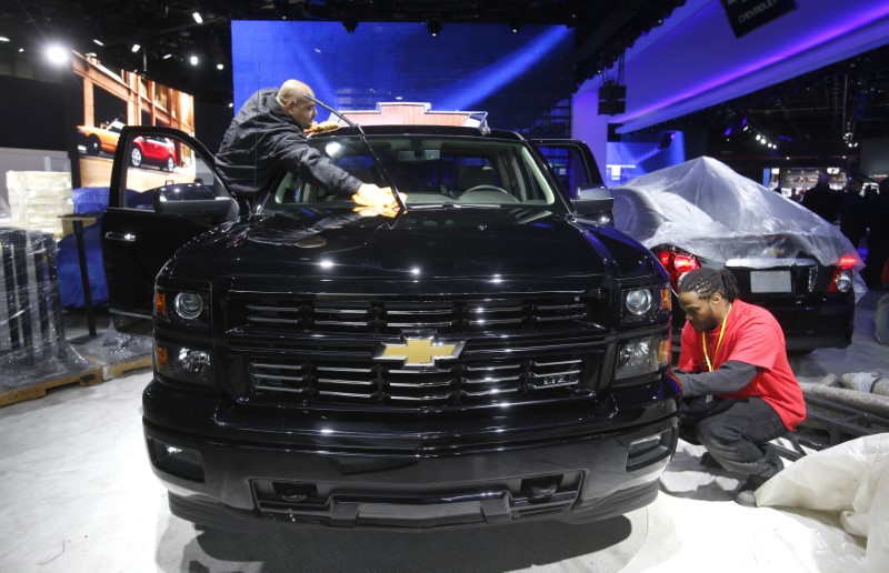 © Reuters. Workers detail a Chevrolet Silverado pickup truck before press days of the North American International Auto Show at Cobo Center in Detroit, Michigan,