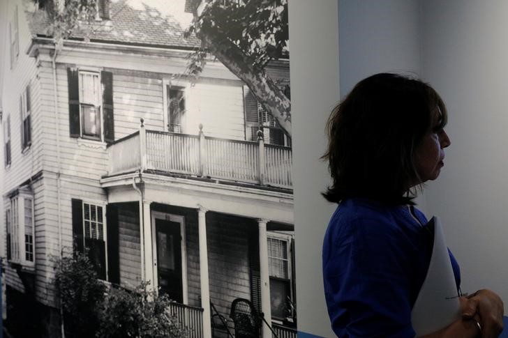 © Reuters. Curator Stacey Bredhoff stands beside a photograph of the home where John F. Kennedy was born at the John F. Kennedy Presidential Library in Boston