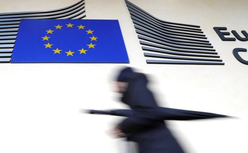 © Reuters. A woman walks past the European flag outside the EU Commission headquarters in Brussels