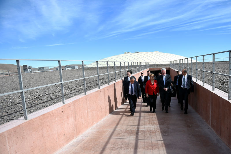 © Reuters. Chile's President Bachelet and Director General of the European Southern Observatory (ESO) De Zeeuw walk at the construction site of the world's largest telescope in Atacama