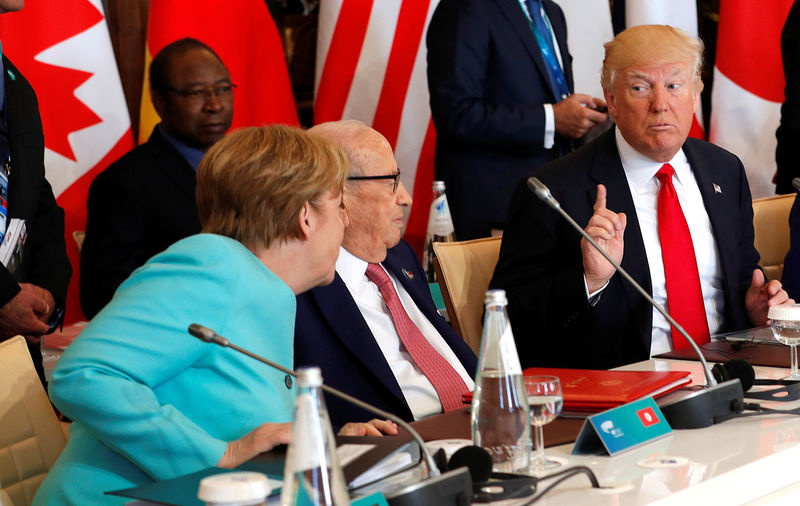 © Reuters. German Chancellor Angela Merkel sits next to Tunisia's President Beji Caid Essebsi and speaks to U.S. President Donald Trump as they attend a G7 expanded session during the G7 Summit in Taormina