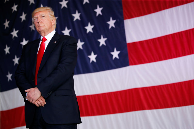 © Reuters. U.S. President Trump stands in front of a U.S. flag while listening to U.S. first lady Melania Trump give a speech to U.S. troops at the Naval Air Station Sigonella before returning to Washington D.C. at Sigonella Air Force Base in Sigonella