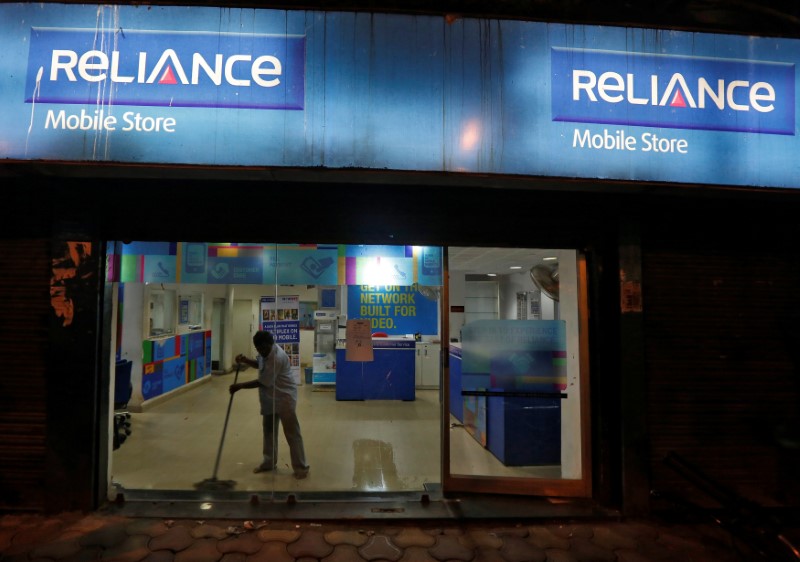 © Reuters. A worker cleans a mobile store of Reliance Communications Lts, controlled by billionaire Anil Ambani, in Kolkata