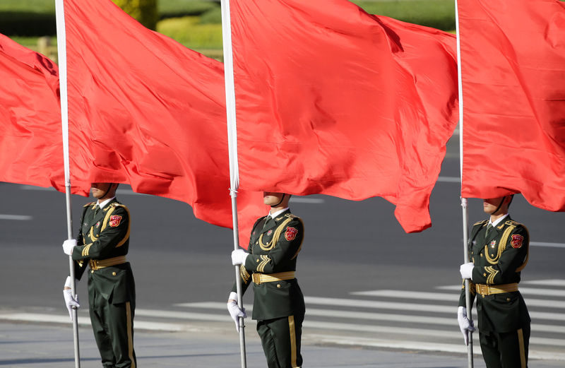 © Reuters. Soldiers from honour guards hold red flags during a welcoming ceremony in Beijing