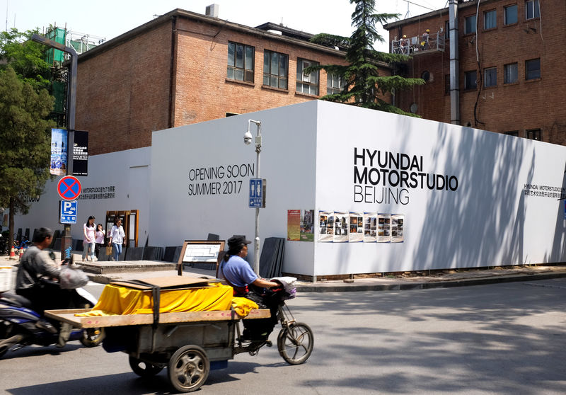 © Reuters. A tricycle drives past the construction site of the Hyundai Motor Studio in Beijing