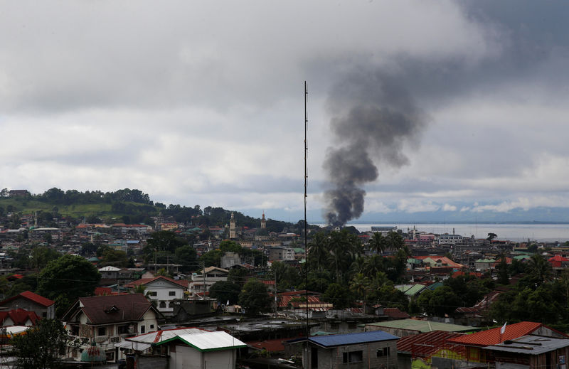 © Reuters. A view of a residential neighbourhood in Marawi City amidst smoke from burning houses due to fighting between government soldiers and the Maute militant group, in southern Philippines