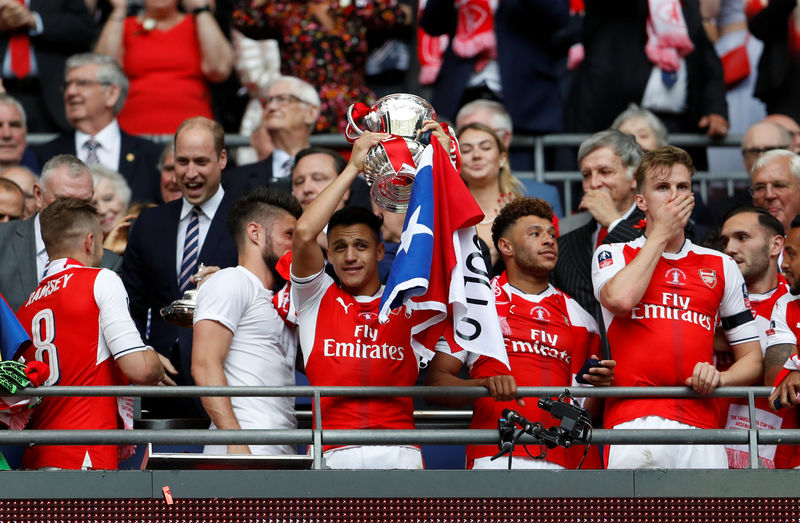 © Reuters. El delantero chileno Alexis Sánchez levanta la Copa FA del fútbol inglés tras la victoria 2-1 del Arsenal sobre el Chelsea en Wembley.