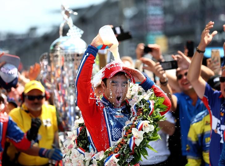 © Reuters. El piloto japonés Takuma Sato se arroja leche encima en el festejo tras ganar las 500 millas de Indianápolis