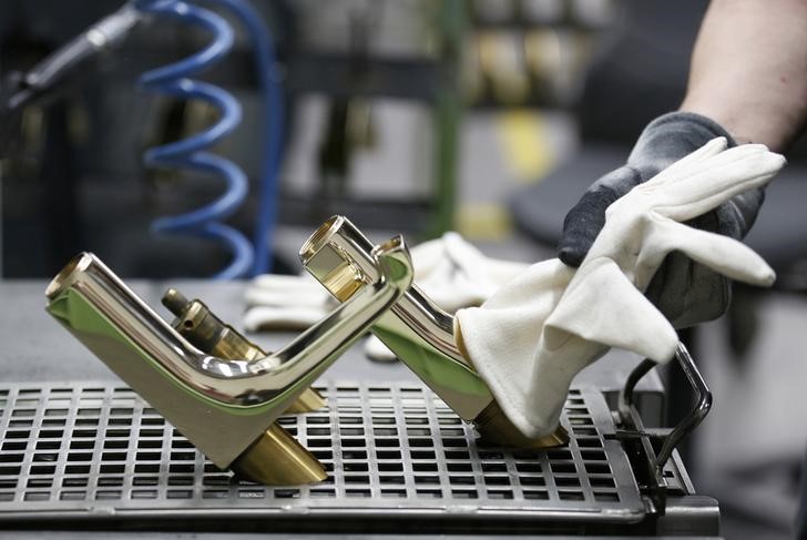 © Reuters. An employee works on plumbing equipment at the polishing stage of the assembly line of bathroom and sanitation company Hansgrohe, in Schiltach, Southwestern Germany