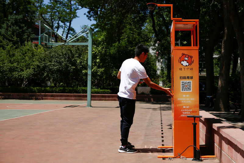 © Reuters. A man uses a court-side basketball vending machine at the Beijing Language and Culture University in Beijing