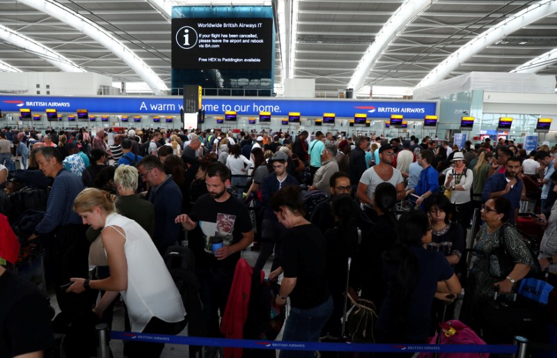 © Reuters. Passageiros aguardam por suas bagagens no balcão de check-in da British Airways no aeroporto Heathrow, em Londres