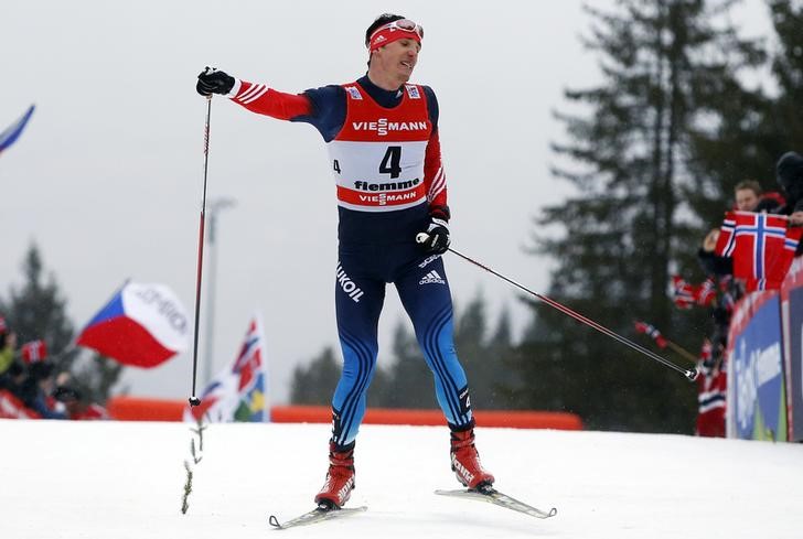 © Reuters. FILE PHOTO: Evgeniy Belov of Russia celebrates as he crosses the finish line after the men's FIS Tour de ski cross-country skiing 9km final climb free pursuit race on the Alpe Cermis in Val di Fiemme