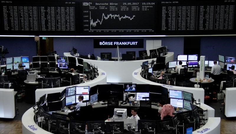 © Reuters. Traders work in front of the German share price index, DAX board, at the stock exchange in Frankfurt