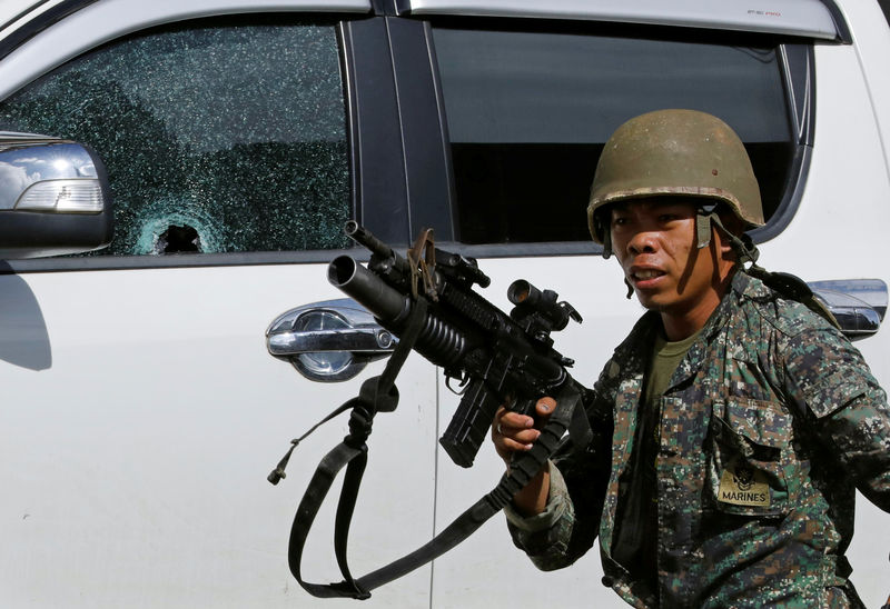 © Reuters. A member of Philippine Marines carries a weapon at the site of fighting between government soldiers and Maute group in Marawi City