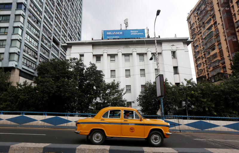 © Reuters. FILE PHOTO: A taxi drives past a Reliance Communications, controlled by billionaire Anil Ambani, office building in Kolkata
