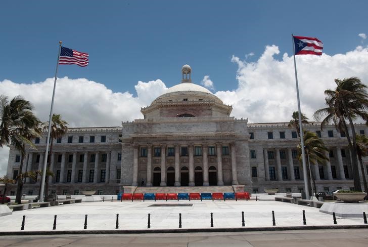 © Reuters. The flags of the U.S. and Puerto Rico fly outside the Capitol building in San Juan