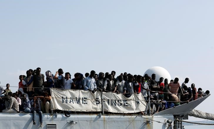 © Reuters. Imigrantes aguardam para desembarcar no porto de Pozzallo, na Itália