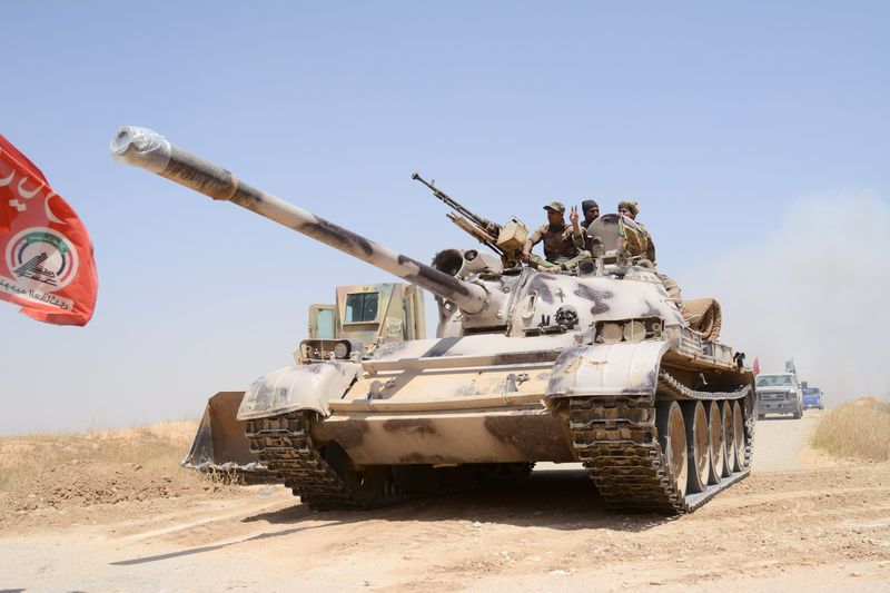 © Reuters. FILE PHOTO: Popular Mobilization Forces (PMF) ride on a tank during a battle with Islamic State militants, at Um Jaris village