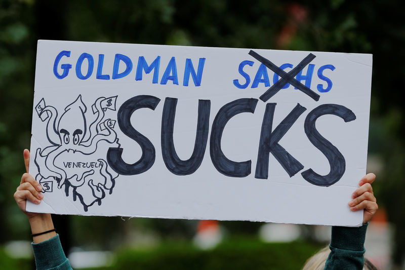 © Reuters. A protester holds a sign as she demonstrates outside of Goldman Sachs headquarters after the company purchased Venezuelan bonds in New York