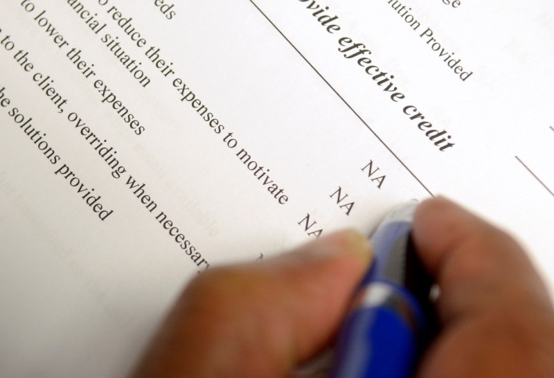 © Reuters. FILE PHOTO: A credit counsellor goes through a checklist with a client in need of help with debt in Orlando