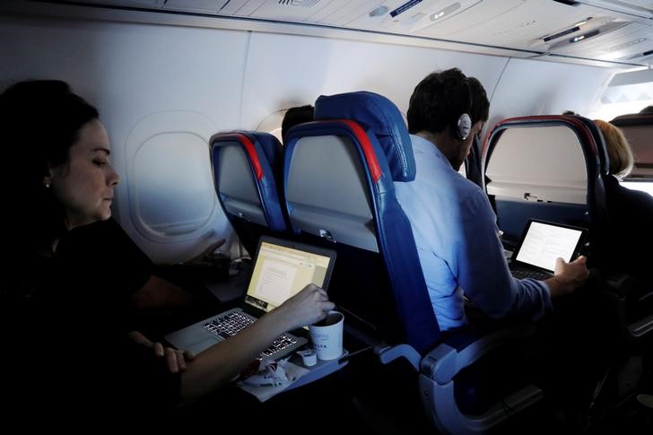 © Reuters. Passageiros usam laptops em vôo do Aeroporto Internacional de Nova York