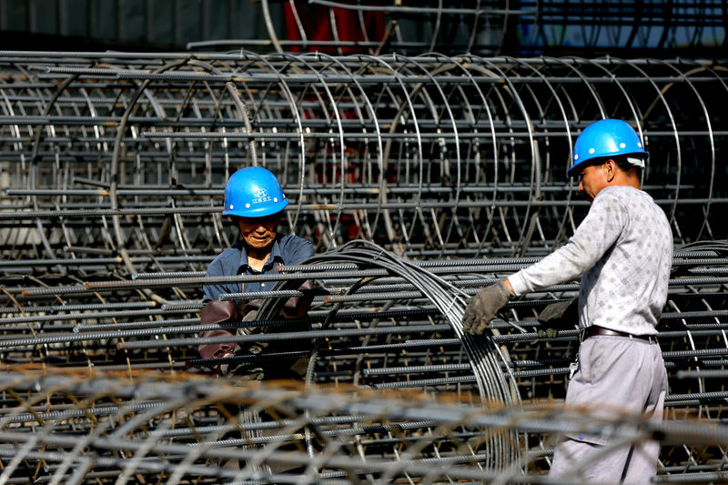 © Reuters. Workers make steel cages at a construction site in Huai'an