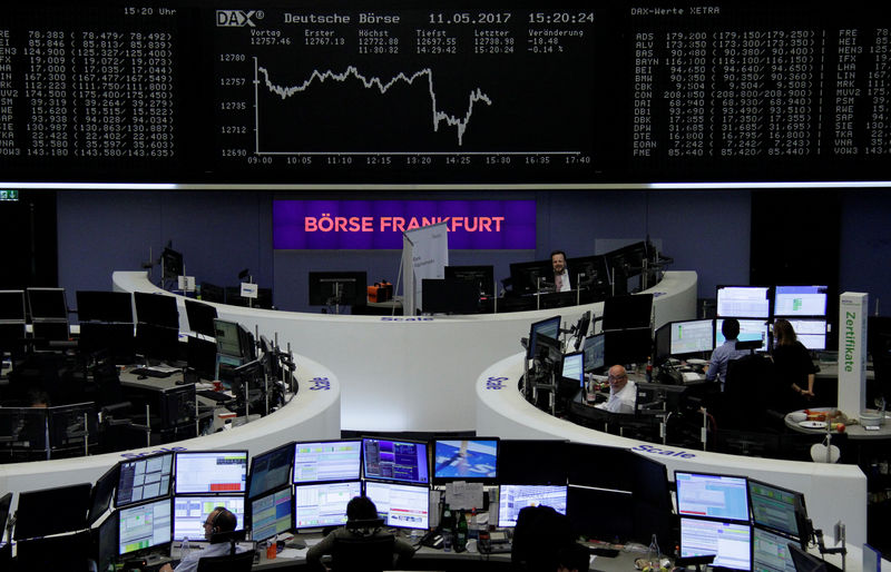 © Reuters. Traders work in front of the German share price index, DAX board, at the stock exchange in Frankfurt