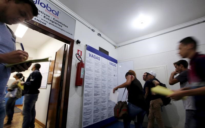 © Reuters. People look at lists of job openings posted at an employment agency in downtown Sao Paulo Brazil