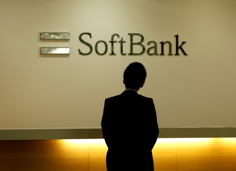 © Reuters. FILE PHOTO: Man looks at the logo of SoftBank Group Corp at the company's headquarters in Tokyo