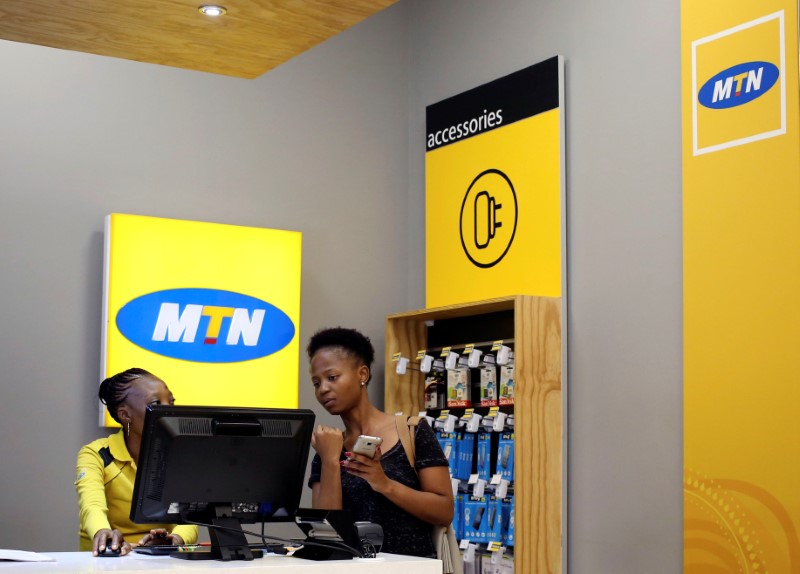 © Reuters. A worker attends to a customer at an MTN shop at mall in Johannesburg