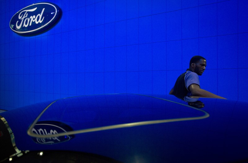 © Reuters. A worker dusts roof of new Ford car during New York International Auto Show in New York