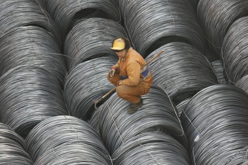 © Reuters. A worker rests on steel to be exported at the Yingkou harbor