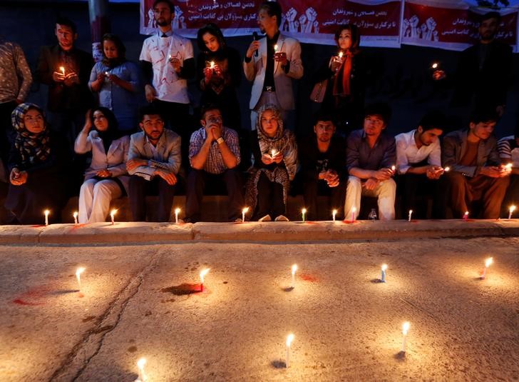 © Reuters. Pessoas acendem velas por vítimas de ataque em Cabul