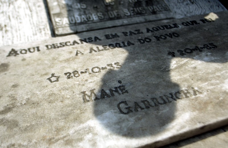 © Reuters. A man casts his Shadow over Garrincha's grave at cemetery in Pau Grande city in Rio de Janeiro.