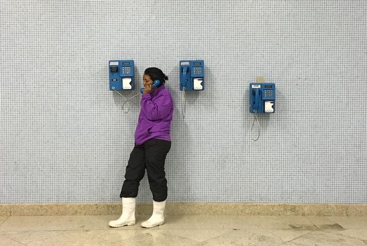 © Reuters. Mulher faz ligação por telefone fixo